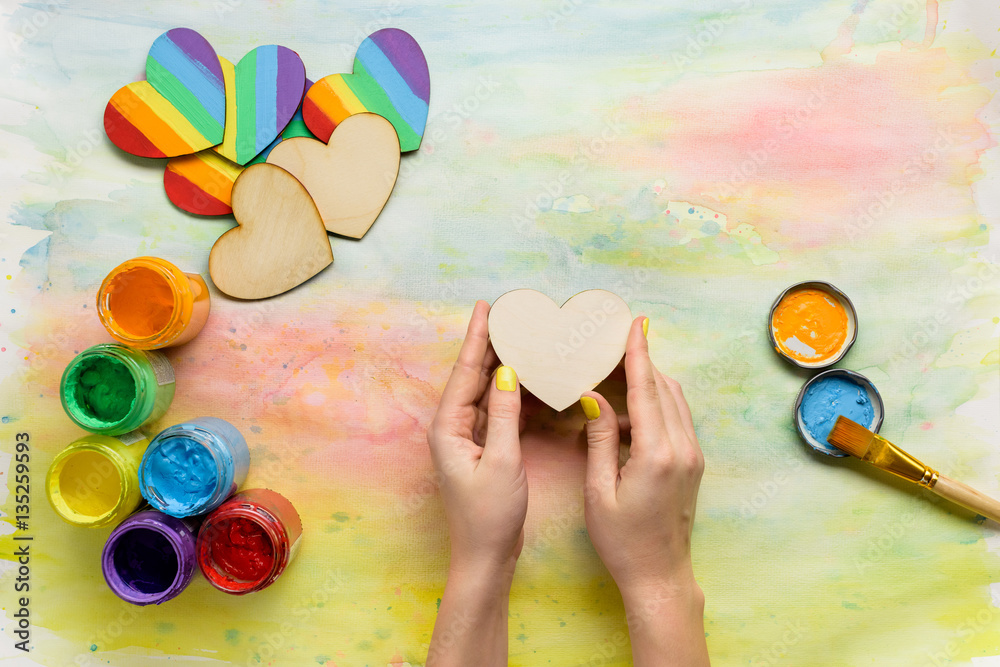 Obraz premium Person painting rainbow on heart shape for St Valentine's Day