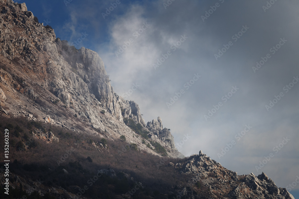 Slope mountain with scattered stones on a background of blue sky