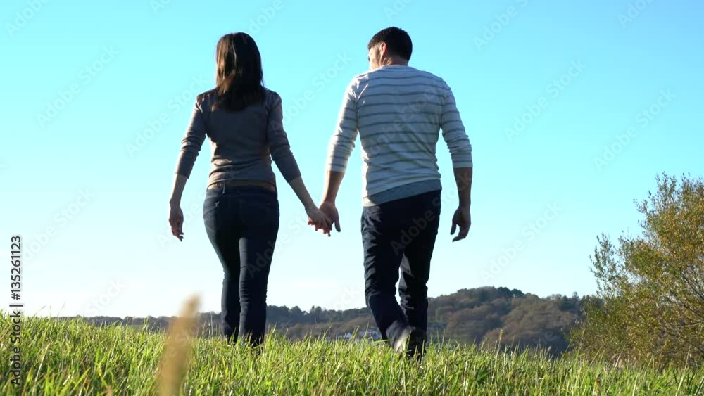 Couple walking in countryside on sunny fall day Couple walking in countryside on sunny fall day