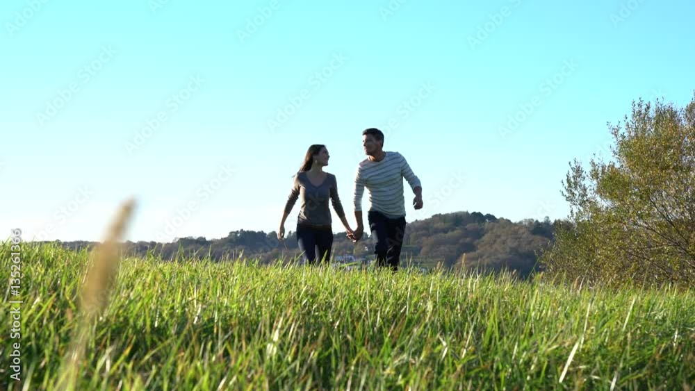 Couple walking in countryside on sunny fall day Couple walking in countryside on sunny fall day