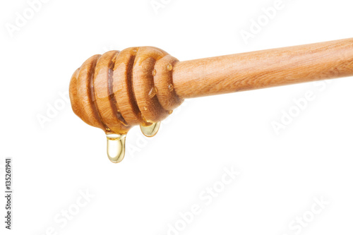 Honey dripping from a wooden dipper on isolate white background. ready to use with clipping path.