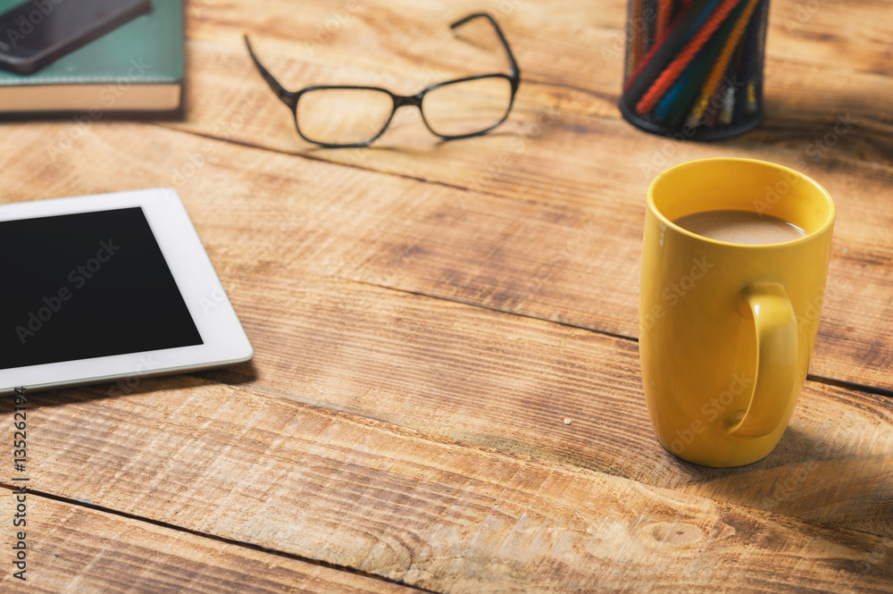 Home desktop with tablet, coffee cup, notepad and pencil Home desktop with tablet, coffee cup, notepad and pencil