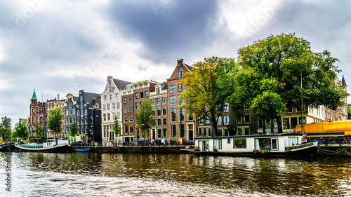 Historic houses dating back to the Middle Ages along the canals seen from a boat in canals of Amsterdam