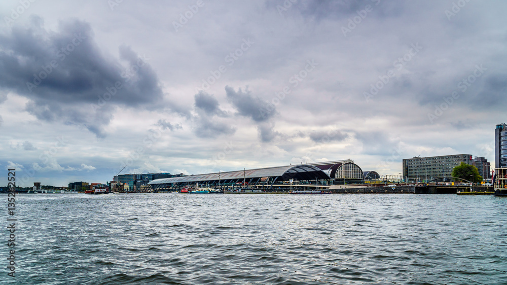 View of Central Train Station from the Harbor named Het IJ in Amsterdam