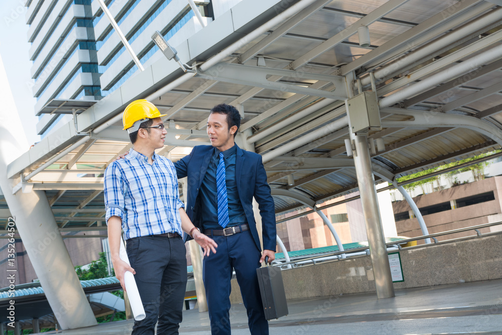 Young Male Architects Discussing with Businessman at Constructio Young Male Architects Discussing with Businessman at Constructio