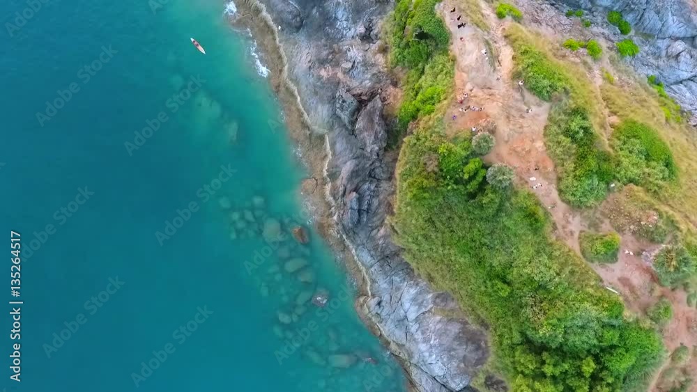 Promthep Cape cliff with palm trees, blue water and rocks. HD aerial birds eye shot. Phuket, Thailand. Promthep Cape cliff with palm trees, blue water and rocks. HD aerial birds eye shot. Phuket, Thailand.