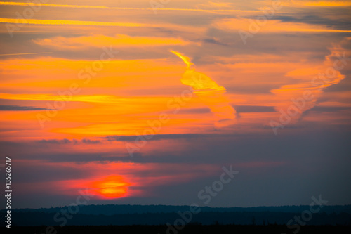 A golden sunset with clouds and chemtrails