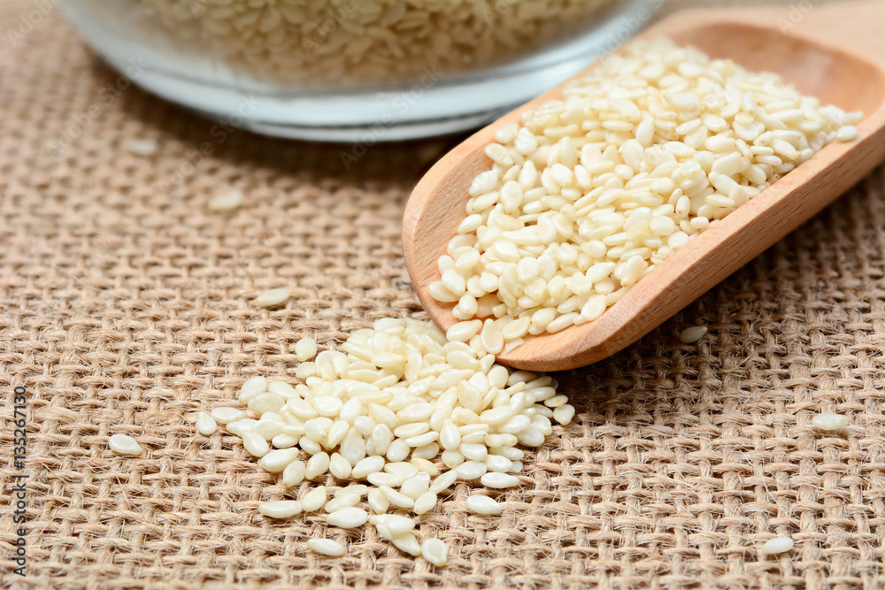 White sesame seeds on wooden spoon White sesame seeds on wooden spoon