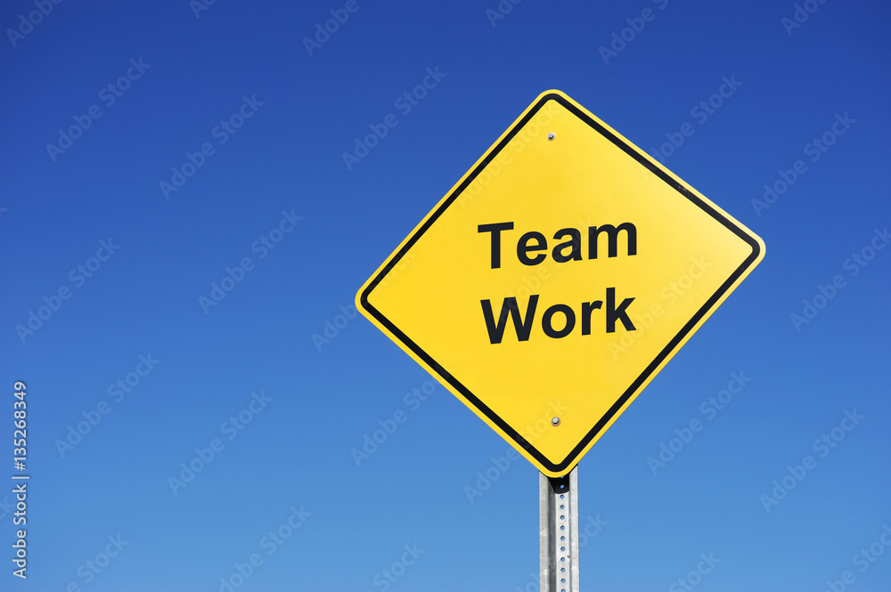road sign with teamwork text on it in front of blue sky road sign with teamwork text on it in front of blue sky