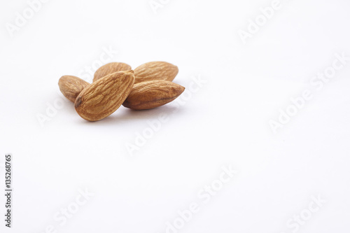 Almonds isolated on a white background, or on a plain wooden table.