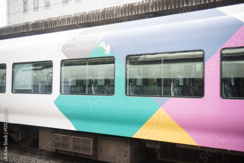 A train car passing by quickly in Japan on a cloudy day.