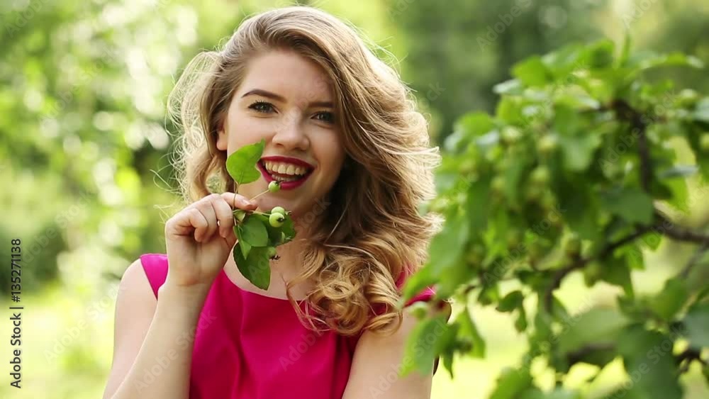 Young attractive girl in red dress. Spring mood. She flirts. Curly hair and sexy lips. Young attractive girl in red dress. Spring mood. She flirts. Curly hair and sexy lips.