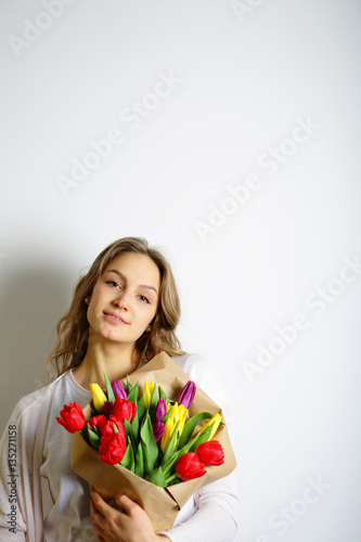 Beautiful young woman holding a bouquet of beautiful flowers. Lo