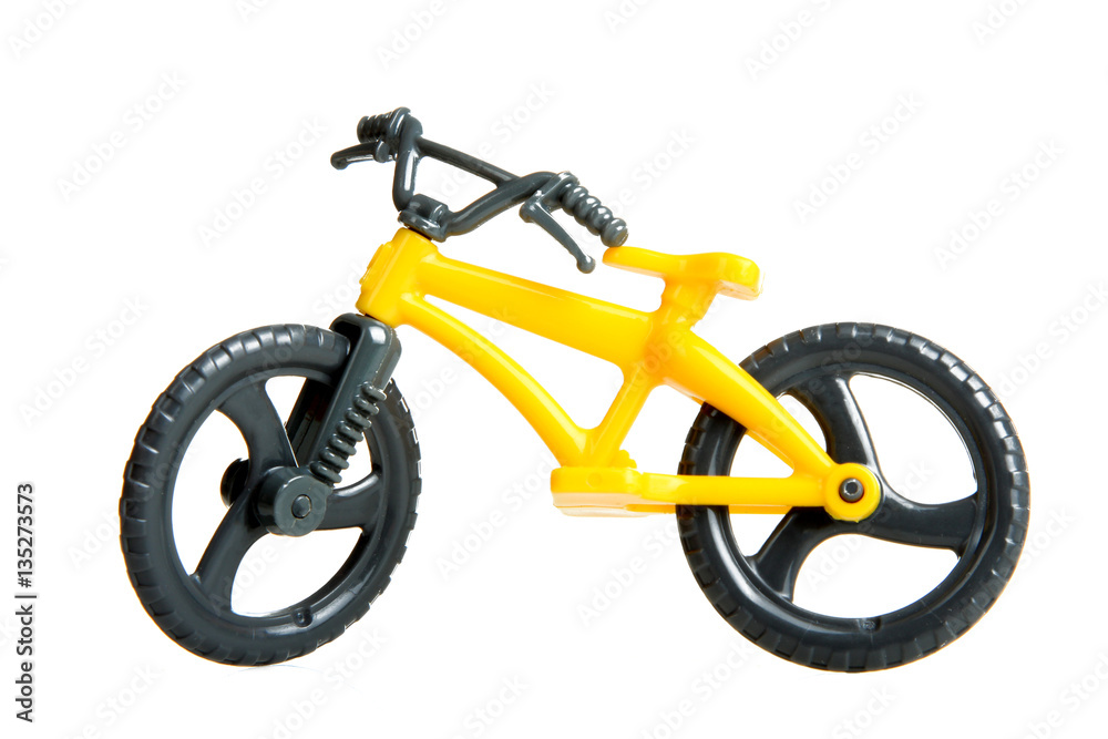 Yellow toy bike with black wheels on a white background isolated.