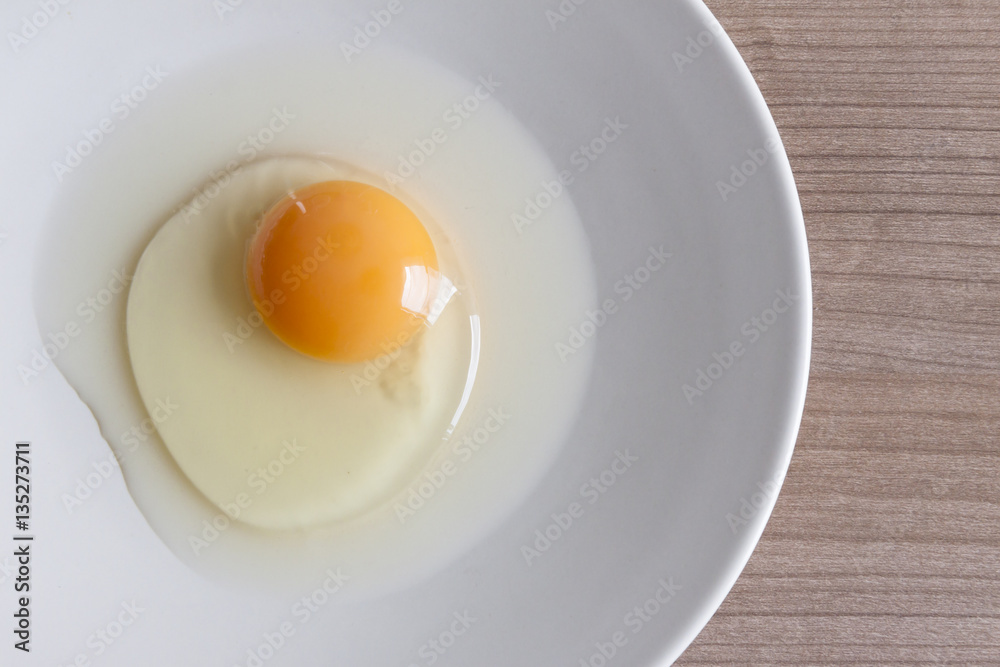 Eggs cooking for breakfast, a protein form yolk and albumen on a white background, or on a plain wooden table. Eggs cooking for breakfast, a protein form yolk and albumen on a white background, or on a plain wooden table.
