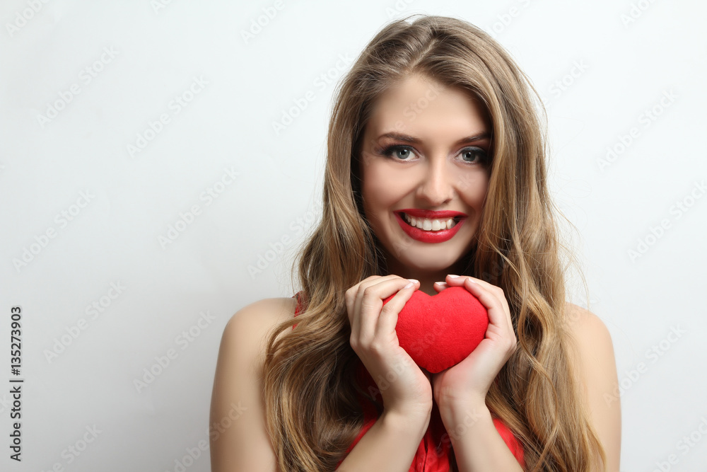 Happy girl holding a red decorative heart. Happy girl holding a red decorative heart.