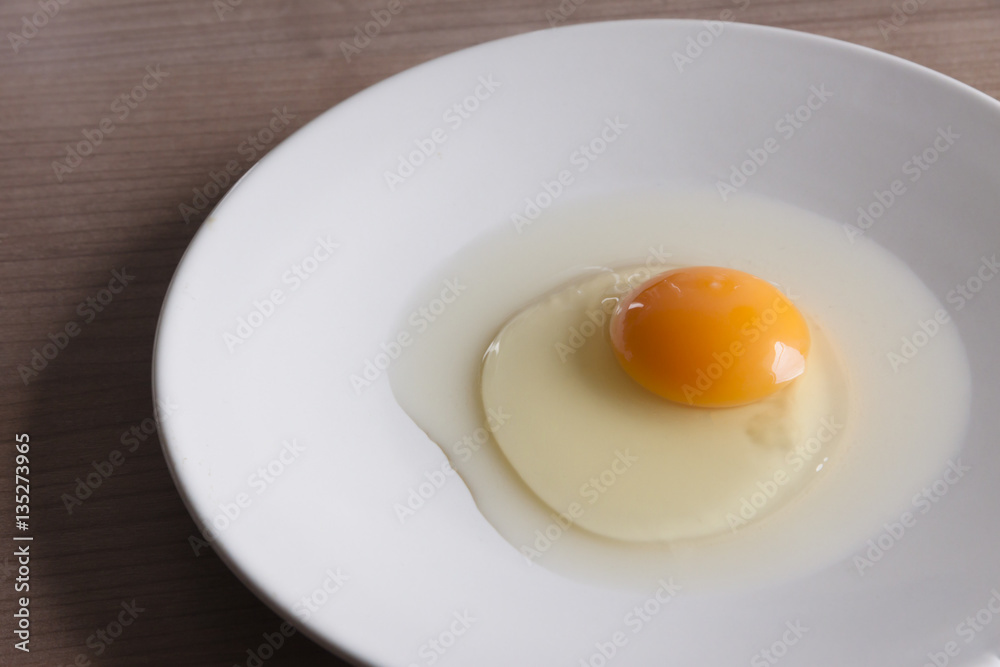 Eggs cooking for breakfast, a protein form yolk and albumen on a white background, or on a plain wooden table. Eggs cooking for breakfast, a protein form yolk and albumen on a white background, or on a plain wooden table.