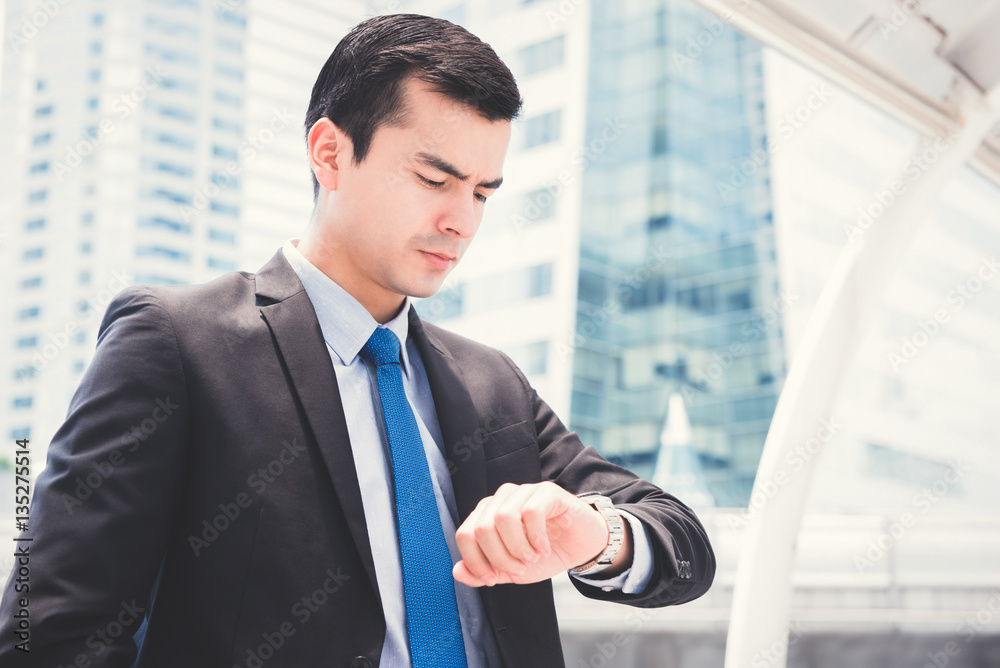 Businessman looking at his watch checking time Businessman looking at his watch checking time