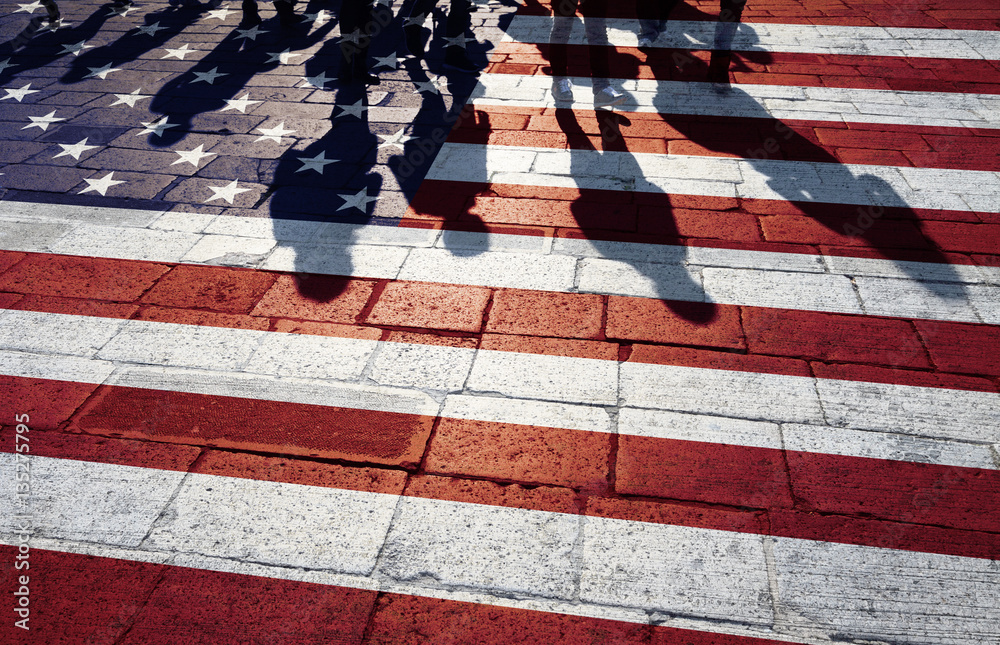 Obraz premium Shadows of group of people walking through the streets with painted Usa flag on the floor. Concept political relations with neighbors.