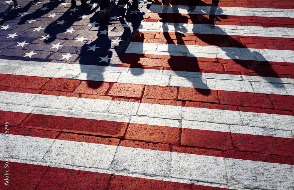 Fototapeta premium Shadows of group of people walking through the streets with painted Usa flag on the floor. Concept political relations with neighbors.