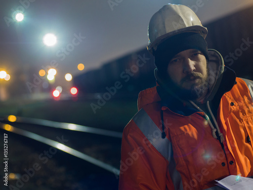 Portrait of young construction worker in helmet at night.