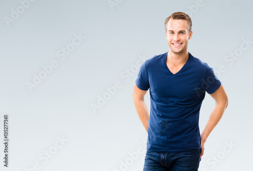 Cheerful young man, over grey photo