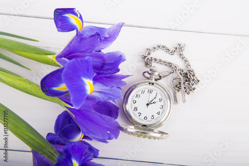 Fototapeta Naklejka Na Ścianę i Meble -  Bouquet of irises with alarm clock on white wooden background