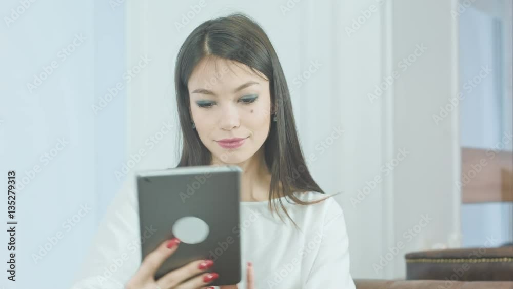 Smiling young woman taking funny selfies on her tablet with her tongue out Smiling young woman taking funny selfies on her tablet with her tongue out