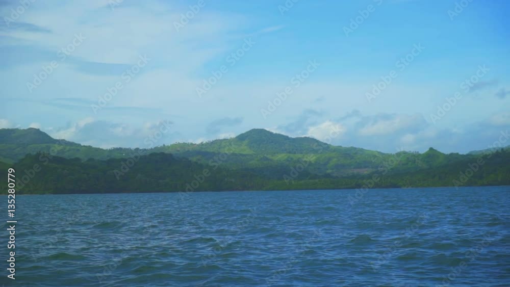 Beautiful landscape of green mountains in the ocean with the vessel moving boat Beautiful landscape of green mountains in the ocean with the vessel moving boat