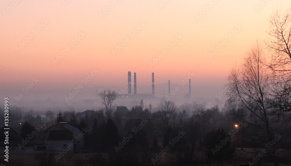 Industrial landscape in the mist at sunset
