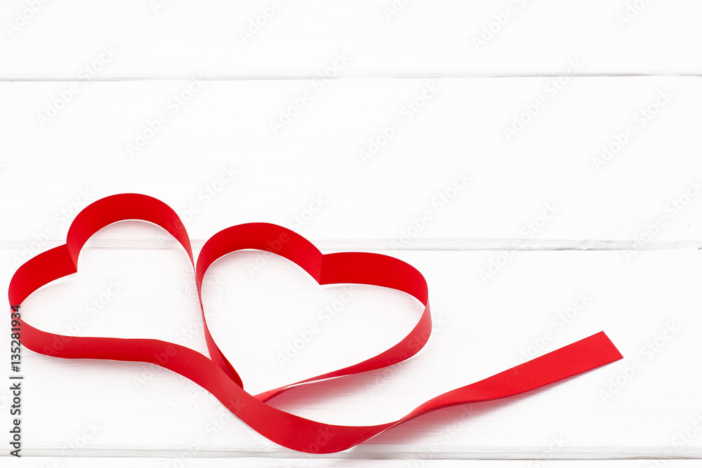 hearts of red ribbon on white wooden background. Top view.