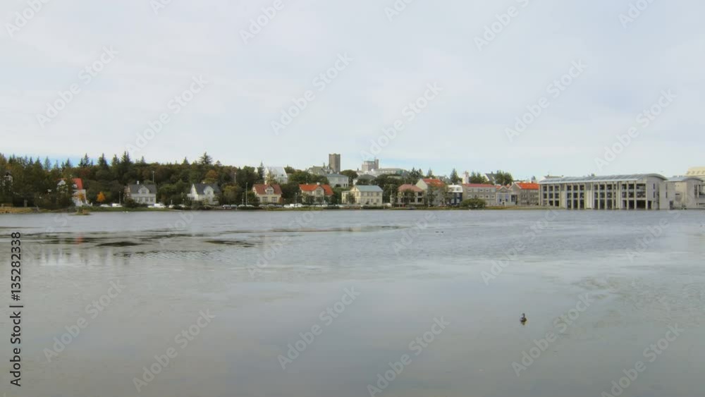 water surface of small lake in northern city, small cottages with multi colored roofs water surface of small lake in northern city, small cottages with multi colored roofs