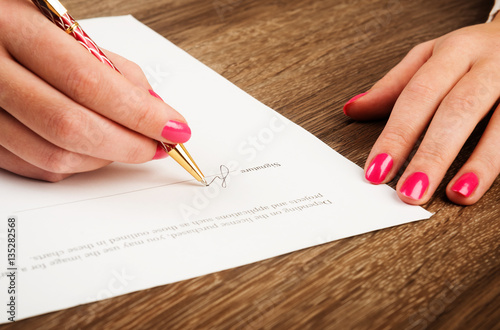 Businesswoman's hand with pen signing a contract.