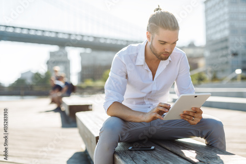 Young businessman in NYC holding a digital device