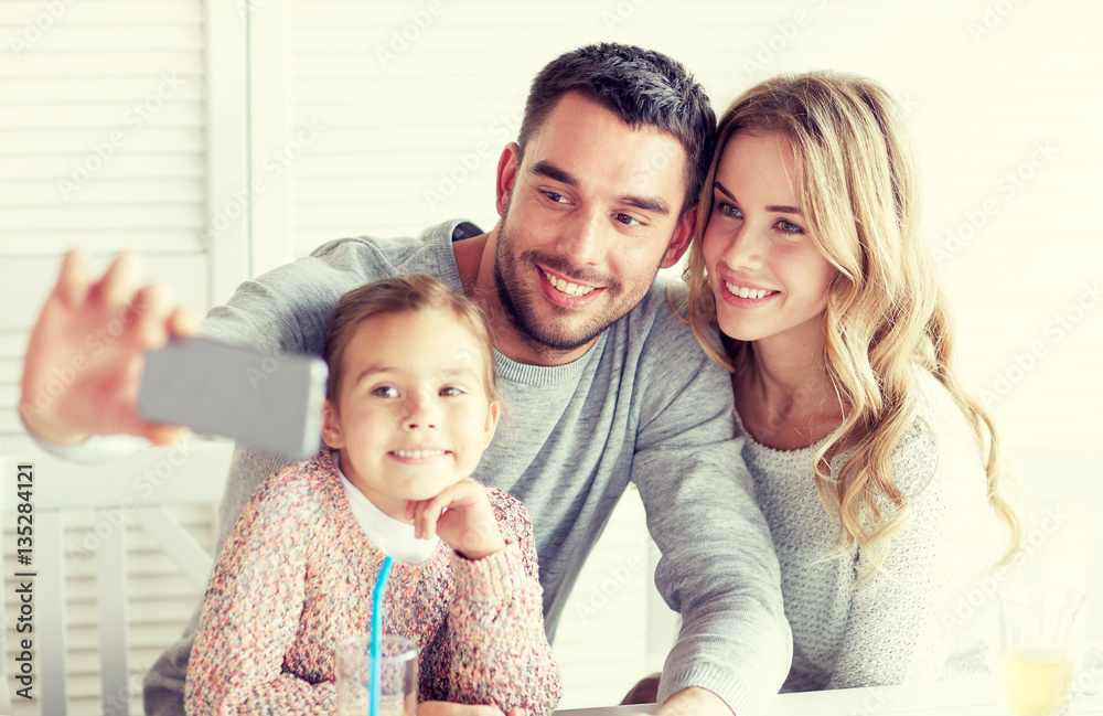 Fototapeta premium happy family taking selfie at restaurant