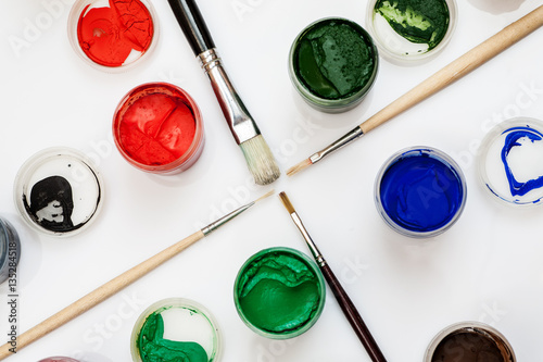 Wallpaper Mural Gouache jars with paintbrushes in the middle on a white background, closeup shot. Torontodigital.ca