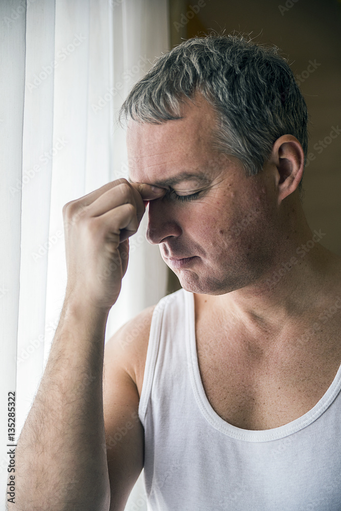 Obraz premium man looking through window looking worried, depressed