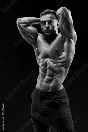 Shirtless male bodybuilder with muscular build strong abs showin