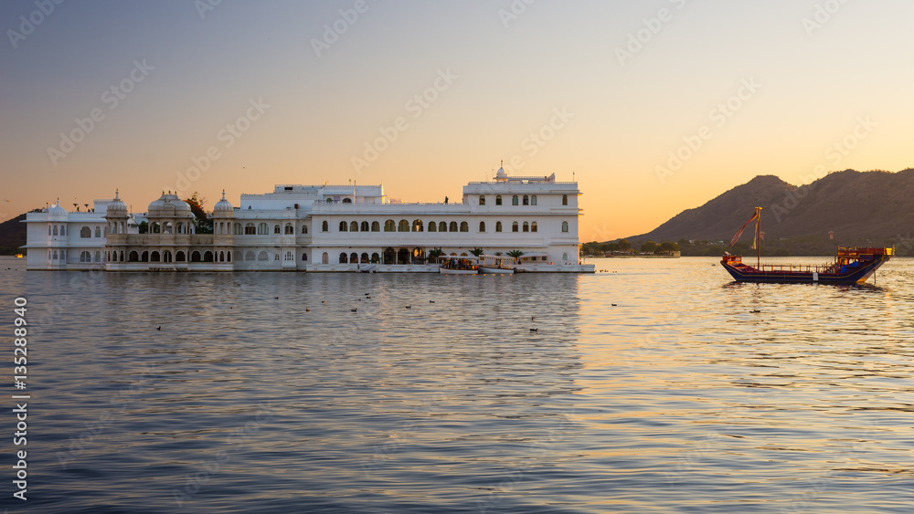 The famous white palace floating on Lake Pichola at sunset. Udaipur, travel destination and tourist attraction in Rajasthan, India