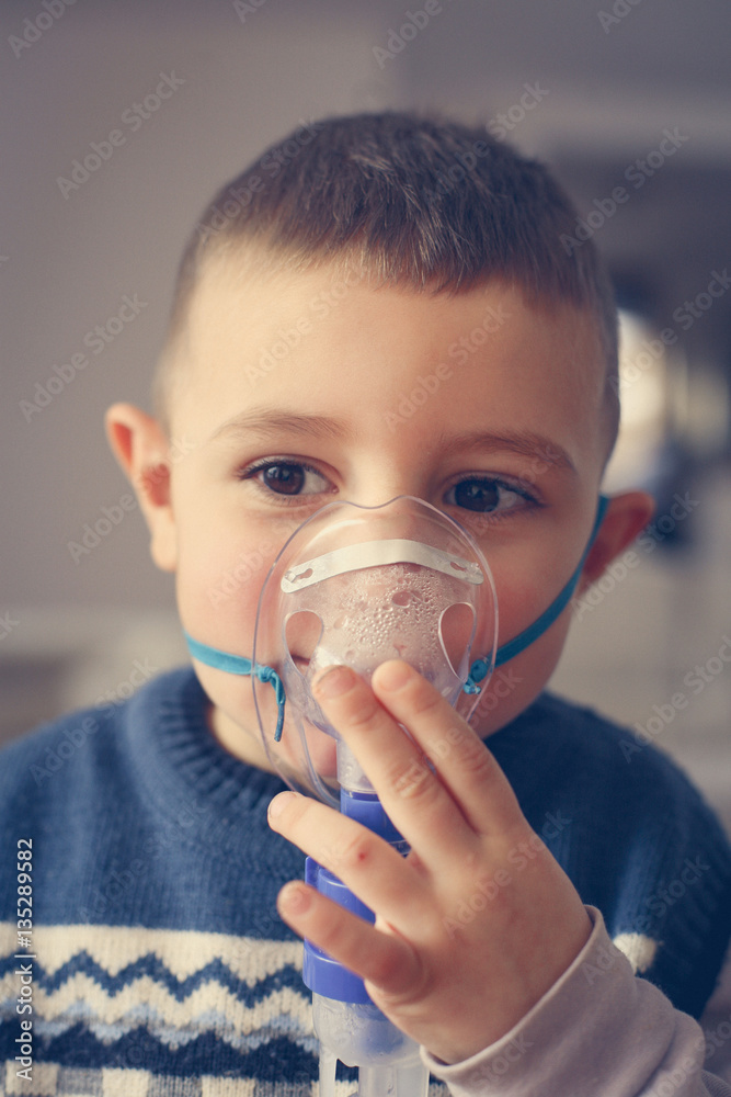 Little boy using inhaler.