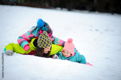 Young mother and two of her little daughters have put up cheerful fight on snow.