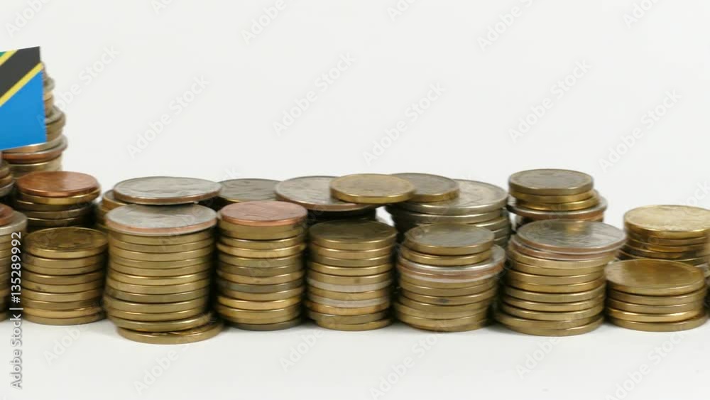 Tanzania flag waving with stack of money coins Tanzania flag waving with stack of money coins