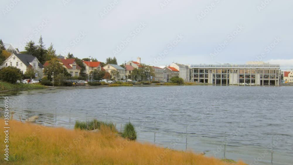 calm cityscape of Reykjavik with lake Tjornin in autumn time, dry yellowed grass calm cityscape of Reykjavik with lake Tjornin in autumn time, dry yellowed grass