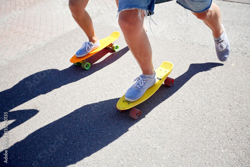 teenage couple riding skateboards on city road