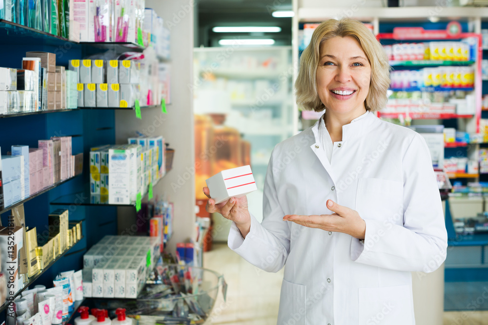 Elderly pharmacist posing in pharmacy