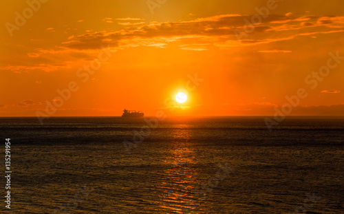 Cargo ship on the horizon at sunset