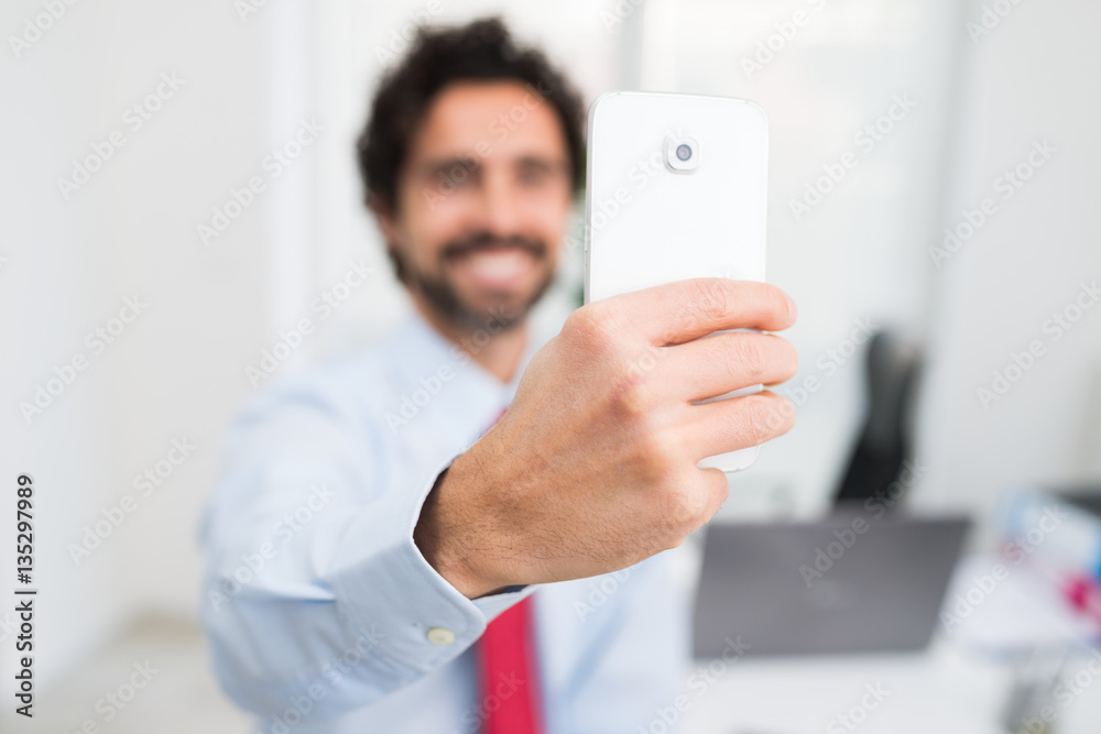 Happy businessman doing a selfie in his office Happy businessman doing a selfie in his office