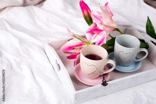 tray with cup of hot tea in the bed, photo