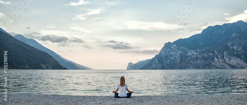 Canvas Print Woman meditating at the lake