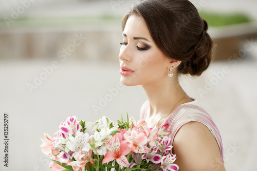 beautiful spring woman with colorful flowers bouquet outdoors